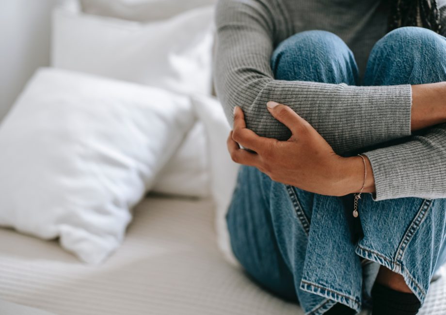 femme se tient les jambes sur son lit car elle a des douleurs vaginales